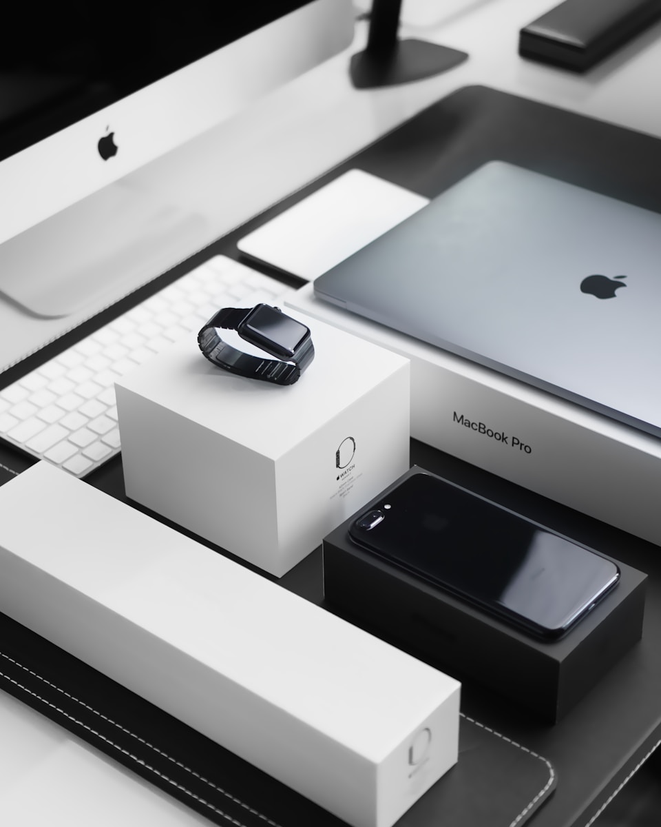 Apple AI Revolution: Innovation Boost or Valuation Trap for Investors 1 space black case Apple Watch, silver MacBook Pro, jet black iPhone 7 Plus, and silver iMac with corresponding boxes